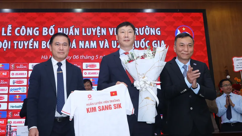 Chủ tịch VFF Trần Quốc Tuấn cùng Phó Chủ tịch VFF Trần Anh Tú tặng hoa chúc mừng đến tân HLV trưởng của ĐTQG Việt Nam Kim Sang-sik. ẢNH: MINH HOÀNG 