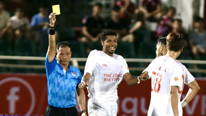 Trọng tài Trần Đình Thịnh rút thẻ vàng tại V-League 2024-2025. ẢNH: DŨNG PHƯƠNG 