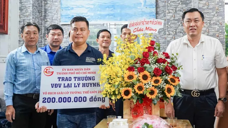 Ông Cao Văn Chóng, Phó Giám đốc Sở Văn hóa và Thể thao TPHCM, thừa ủy quyền Ủy ban Nhân dân TPHCM trao 200 triệu đồng tiền thưởng cho kỳ vương Lại Lý Huynh. ẢNH: TÂM HÀ 
