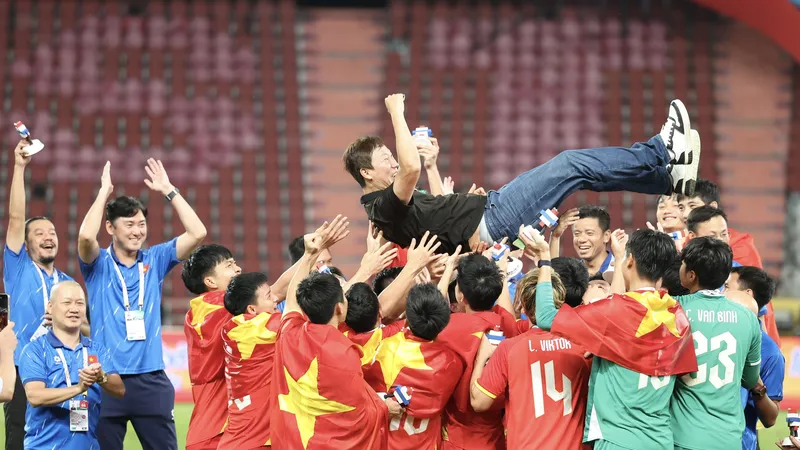 Các tuyển thủ U22 Việt Nam tung hô HLV Kim Sang-sik sau khi giành huy chương vàng SEA Games 33. ẢNH: DŨNG PHƯƠNG