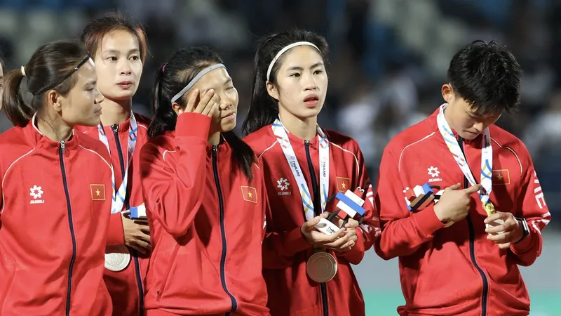 Thái Thị Thảo, Huỳnh Như, Nguyễn Thị Thanh Nhã và Trần Thị Hải Linh thẫn thờ ở bục nhận huy chương. ẢNH: DŨNG PHƯƠNG