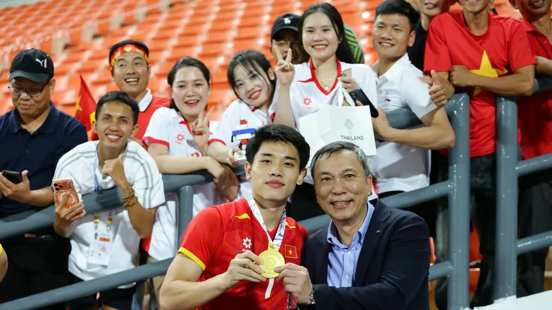 Tiền đạo Nguyễn Đình Bắc ăn mừng tấm huy chương vàng SEA Games cùng Chủ tịch VFF Trần Quốc Tuấn. ẢNH: DŨNG PHƯƠNG 