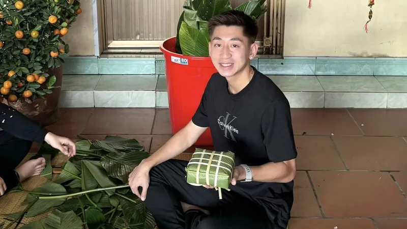 Trung vệ Nguyễn Nhật Minh gói bánh chưng cùng gia đình. ẢNH: FBNV 