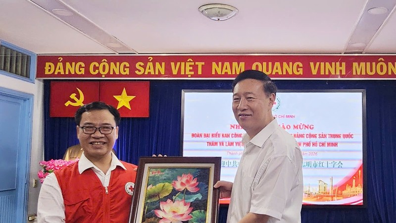 胡志明市红十字会主席阮明日向中国共产党中央社会工作部副部长赵世堂赠送礼物。图：心雨