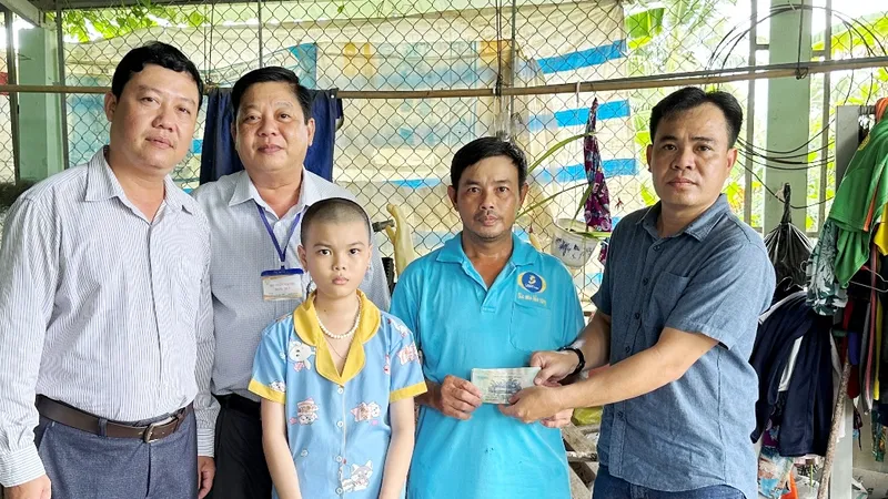 Đại diện Báo SGGP phối hợp cùng chính quyền địa phương trao hỗ trợ 17 triệu đồng giúp bé Ngọc Ánh có tiền chữa bệnh