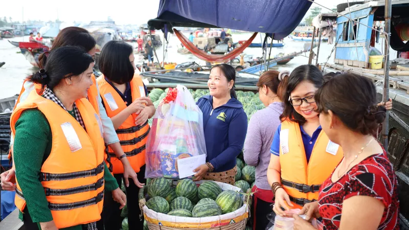 Tiểu thương vui mừng được nhận quà tết khi đang bán trên sông nước chợ nổi Cái Răng. Ảnh: PHẠM TRUNG