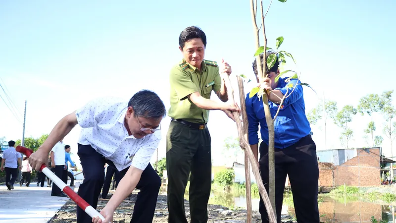 Ông Trương Cảnh Tuyên, Phó Chủ tịch Thường trực UBND tỉnh Hậu Giang (bìa trái) tham gia trồng cây sáng 6-7