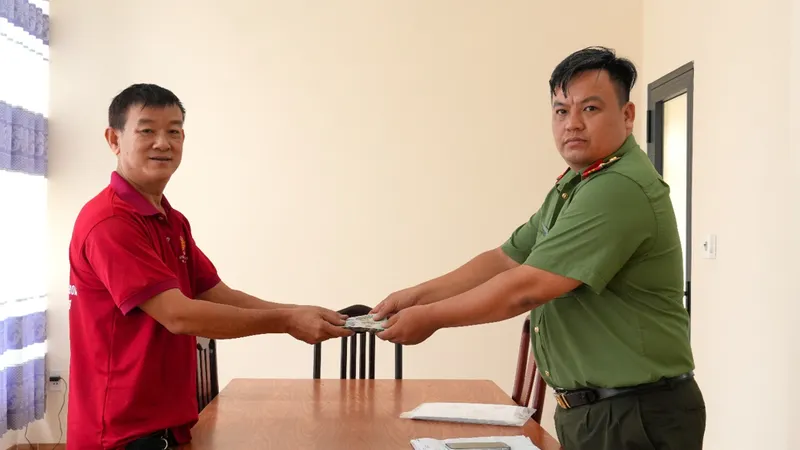 Ông Dương Quốc Quân trao số tiền lại cho cơ quan công an 