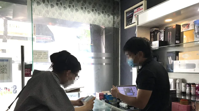 Nhân viên một cửa hàng bán thuốc kích dục chào mời khách hàng