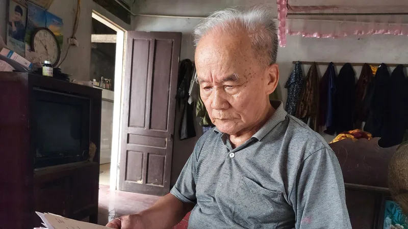 Ông Vương Khả Khai bên tập giấy tờ ghi chép tìm kiếm phần mộ liệt sĩ