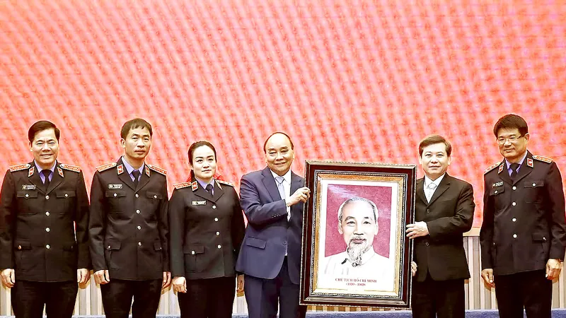 Chủ tịch nước Nguyễn Xuân Phúc trao bức chân dung Chủ tịch Hồ Chí Minh cho ngành kiểm sát nhân dân. Ảnh: QUANG PHÚC