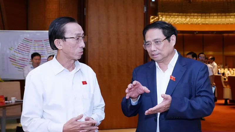 Thủ tướng Phạm Minh Chính trao đổi với đại biểu Quốc hội Trần Hoàng Ngân bên lề phiên thảo luận về tình hình thực hiện kế hoạch phát triển kinh tế - xã hội và ngân sách Nhà nước những tháng đầu năm 2023. Ảnh: VIẾT CHUNG