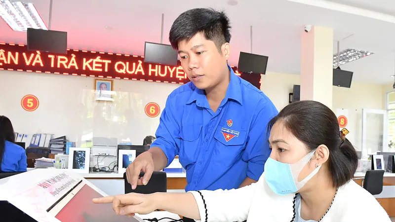 Đoàn viên thanh niên hướng dẫn người dân tra cứu dịch vụ công trực tuyến. Ảnh: VIỆT DŨNG