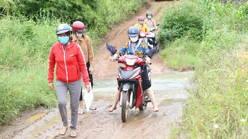 Giáo viên Trường Tiểu học Mạc Thị Bưởi băng rừng để lên lớp. Ảnh: MAI CƯỜNG 