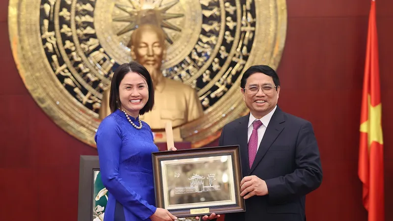 Thủ tướng Phạm Minh Chính tặng quà cho đại diện cộng đồng người Việt Nam tại Trung Quốc. Ảnh: TTXVN