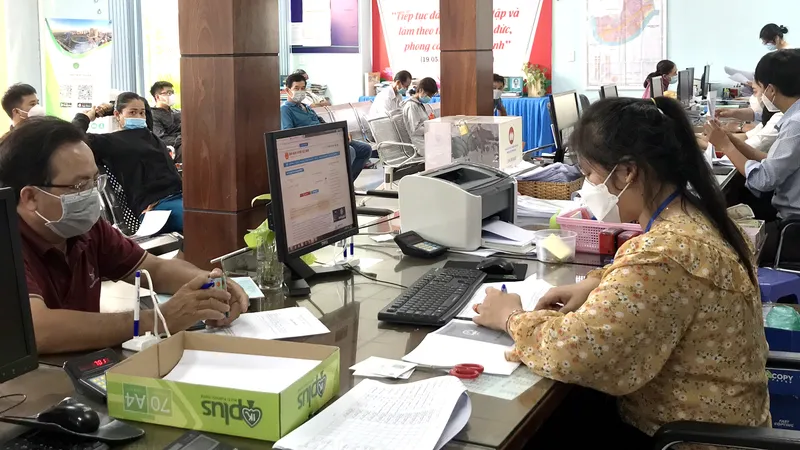 Công chức phường Hiệp Bình Chánh, TP Thủ Đức, TPHCM tiếp nhận giải quyết hồ sơ cho người dân. Ảnh: NGÔ BÌNH