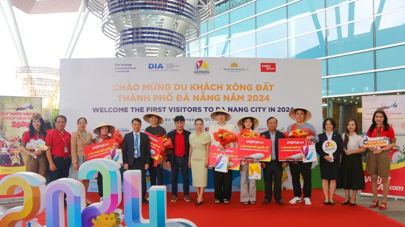 Những du khách quốc tế trên chuyến bay đầu tiên đến Đà Nẵng được nhận hoa và quà tặng. Ảnh: XUÂN QUỲNH