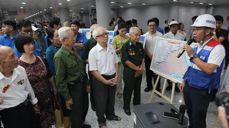 Nhân viên Ban Quản lý đường sắt đô thị TPHCM giới thiệu dự án metro số 1 đến các cựu binh Điện Biên Phủ và đại biểu tham gia buổi chạy thử nghiệm metro. Ảnh: DŨNG PHƯƠNG