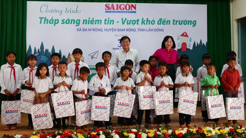 Tổng Biên tập Báo SGGP Tăng Hữu Phong và Phó Tổng Biên tập Báo SGGP Bùi Thị Hồng Sương trao quà của Chương trình "Thắp sáng niềm tin - Vượt khó đến trường" do báo tổ chức đến học sinh tại xã Đạ M'rông, huyện Đam Rông, tỉnh Lâm Đồng. Ảnh: ĐOÀN KIÊN