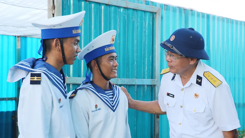 Thượng tá Phạm Văn Hưng, từng là trưởng ngành hỏa lực của tàu HQ-505, thăm hỏi chiến sĩ đảo Cô Lin. Ảnh: VÕ THẮM