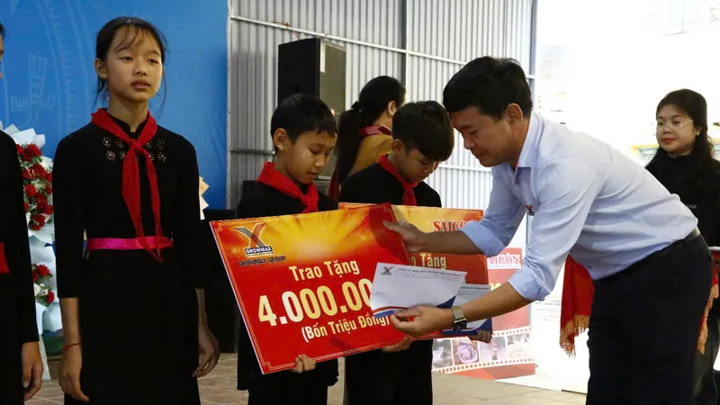 Ông Đặng Văn Thành, Giám đốc khu vực miền Bắc của Tập đoàn GrowMax trao học bổng cho các em học sinh