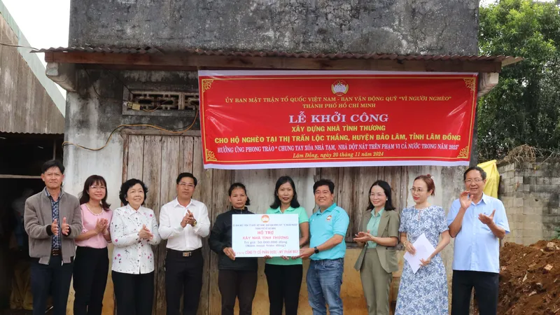 Đoàn trao hỗ trợ xây nhà Đại đoàn kết đến gia đình bà Ka Đi Ơng (đồng bào dân tộc Mạ), phía sau là căn nhà mục nát của 4 mẹ con bà