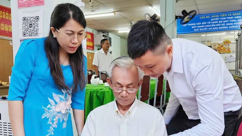 Tình nguyện viên hướng dẫn người dân cài đặt chữ ký số tại UBND phường 12, quận 3, TPHCM
