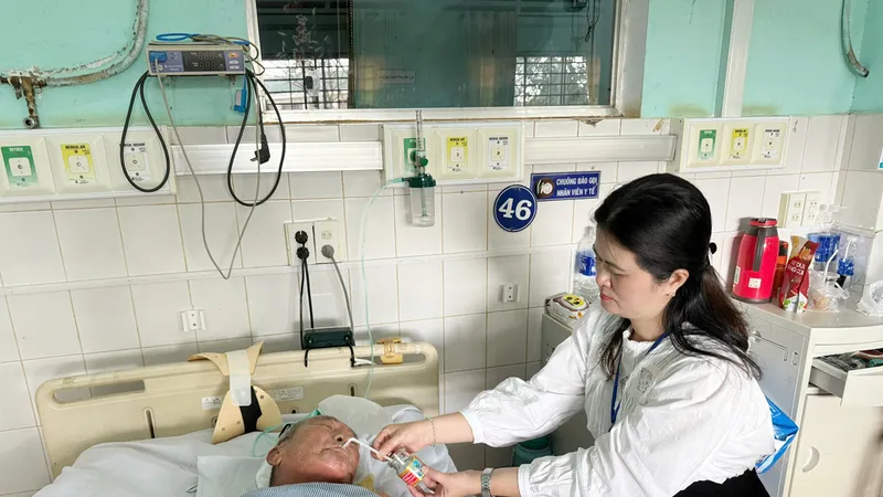 Bà Nguyễn Thị Nga, nhân viên chuyên trách Tổ công tác xã hội, Bệnh viện Đa khoa tỉnh Gia Lai chăm sóc một người bệnh. Ảnh: VHP