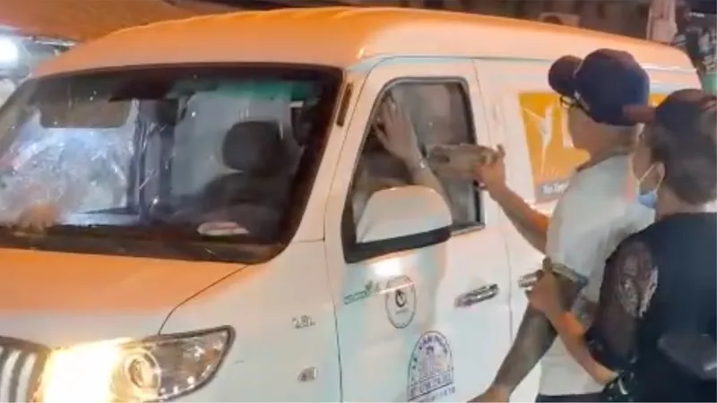 Hình ảnh người đàn ông cầm đá đập vào xe ô tô 