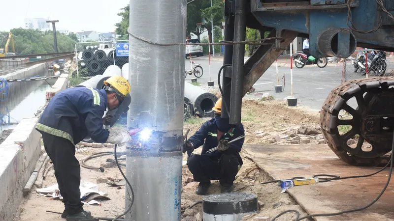 Thi công cọc thép kè bờ, thuộc dự án nạo vét kênh Bến Đình. Ảnh: QUANG VŨ