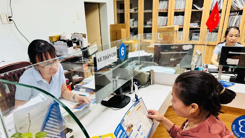 Viên chức BHXH TPHCM tư vấn chính sách BHXH cho người dân. Ảnh: ĐÔNG SƠN