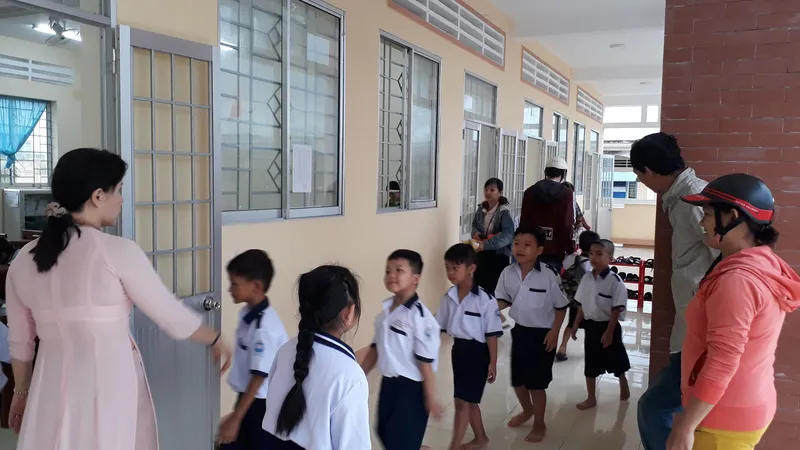 Giáo viên Trường Tiểu học Văn Lang (phường An Xuyên, tỉnh Cà Mau) hướng dẫn học sinh vào lớp học. Ảnh: TẤN THÁI