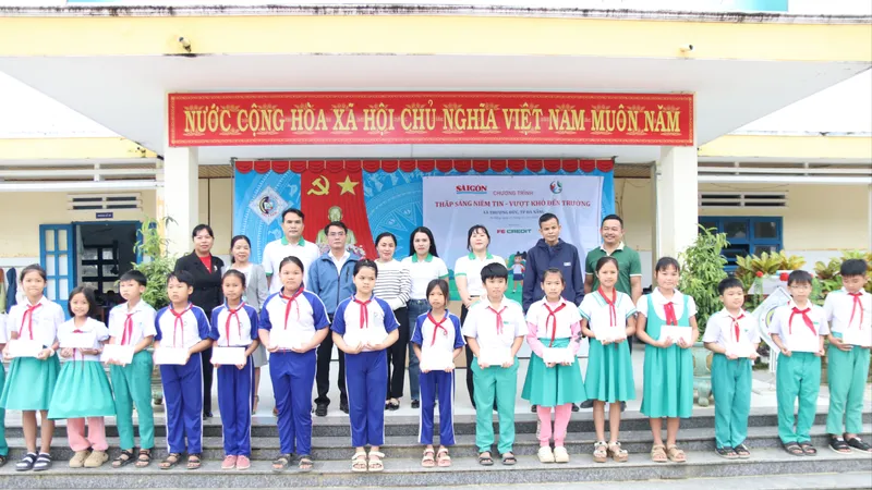Báo SGGP phối hợp cùng Công ty Tài chính TNHH Ngân hàng Việt Nam Thịnh Vượng SMBC (FE CREDIT) và chính quyền địa phương trao quà hỗ trợ cho học sinh vùng “rốn lũ” xã Thượng Đức. Ảnh: NGUYỄN CƯỜNG