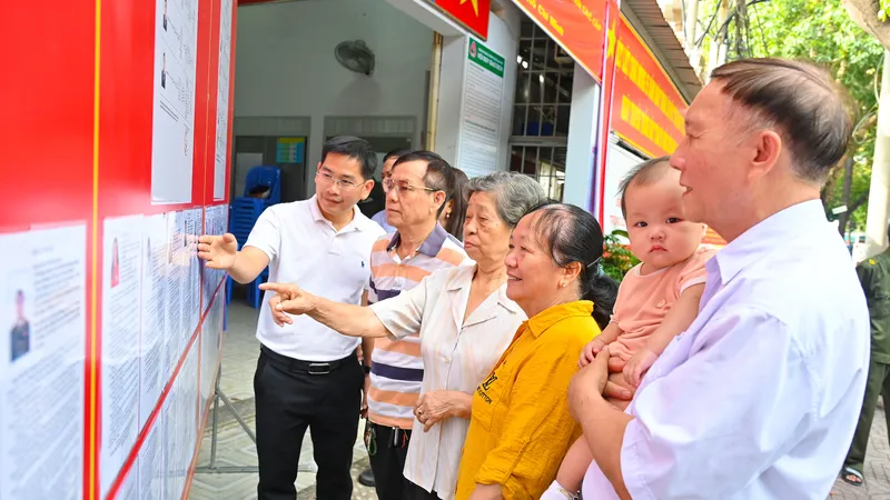 Lãnh đạo địa phương cùng các thành viên Tổ bầu cử Khu vực bầu cử số 30 phường Tam Thắng, cùng cử tri địa phương theo dõi thông tin tiểu sử các ứng cử viên