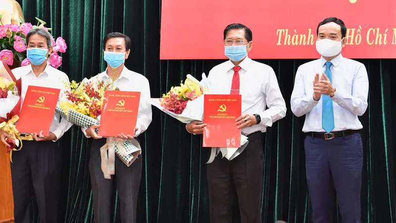 Phó Bí thư Thường trực Thành ủy Trần Lưu Quang trao quyết định cho 3 đồng chí Lê Văn Tân, Nguyễn Thọ Truyền, Đặng Nguyễn Thanh Minh. Ảnh: VIỆT DŨNG