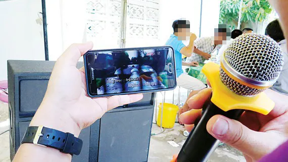 Chỉ cần dàn loa, micro kết nối phần mềm karaoke trên điện thoại di động là đủ hành hạ làng xóm. Ảnh: DŨNG PHƯƠNG