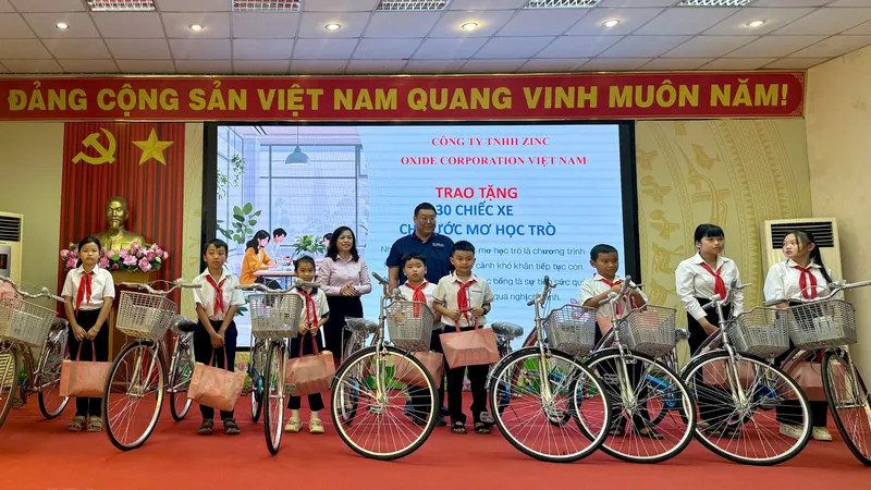 Đại diện Công ty TNHH Zinc Oxide Corporation Việt Nam trao xe đạp cho các em học sinh khó khăn