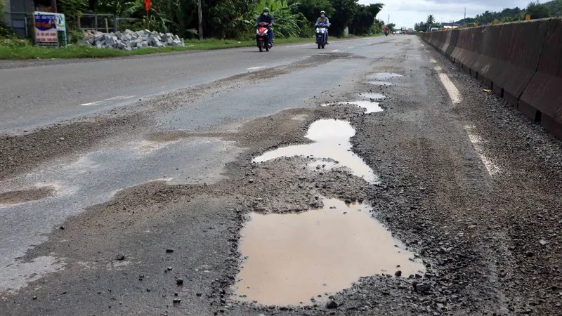 Mặt đường quốc lộ 1A, hư hỏng, lổm chổm đá dăm.
