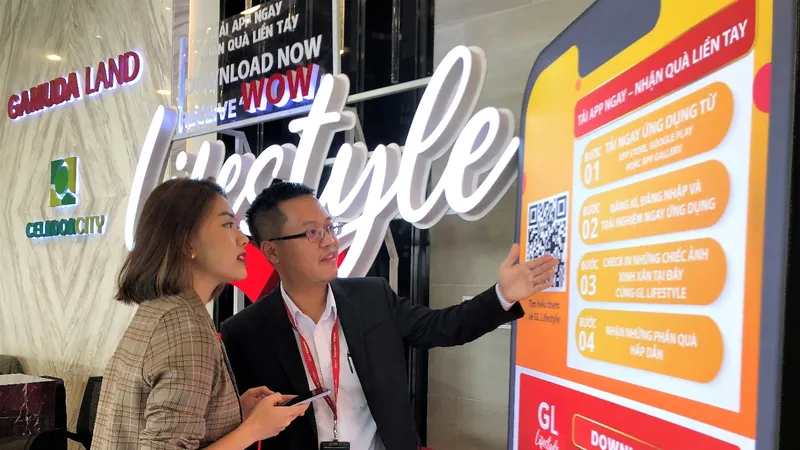 Nhân viên Gamuda Land hướng dẫn khách hàng cài đặt app tại khu nhà mẫu trưng bày