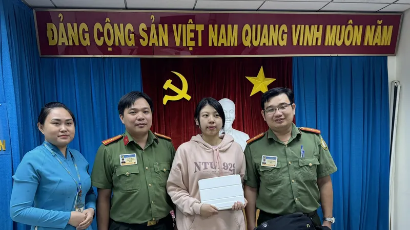 Cô Huang Huy Yu xúc động nhận lại tài sản từ Thiếu tá Trần Minh Cường (bìa phải) 