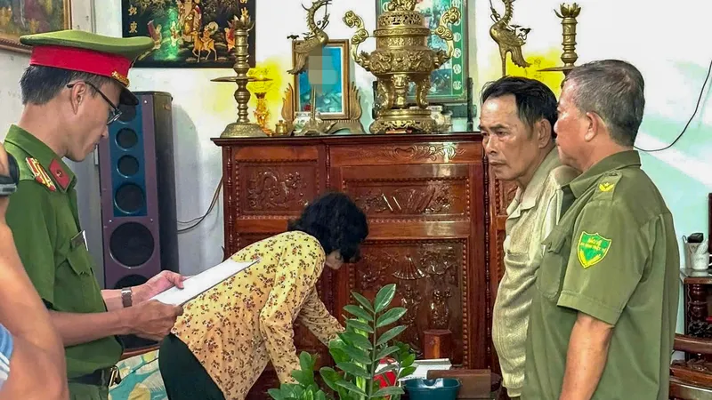 Công an đọc quyết định khởi tố bị can, lệnh bắt tạm giam đối với ông Lê Văn Hoàng. Ảnh: CTV