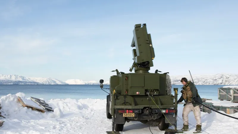 Một binh sĩ Na Uy tiếp nhiên liệu cho phương tiện chở radar thuộc hệ thống phòng không NASAMS. Ảnh: Bộ Quốc phòng Na Uy/Baotintuc