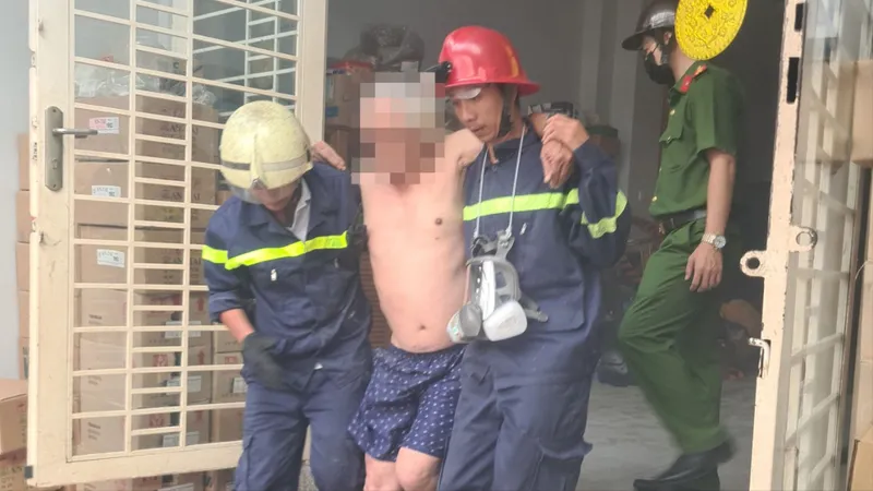 Lực lượng chức năng đưa người đàn ông lớn tuổi trong căn nhà cháy ra ngoài 