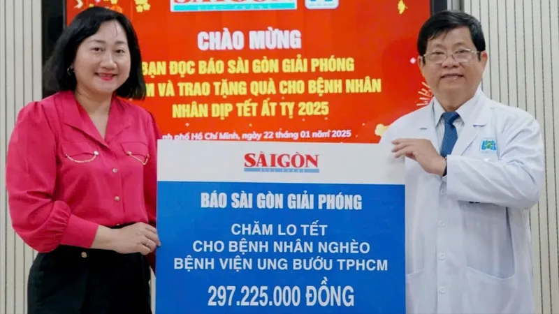 Bà Bùi Thị Hồng Sương - Phó Tổng Biên tập Báo Sài Gòn Giải Phóng trao bảng tượng trưng cho TS.BS. Diệp Bảo Tuấn - Giám đốc Bệnh viện Ung Bướu TP. Hồ Chí Minh. Ảnh : VIỆT NGA