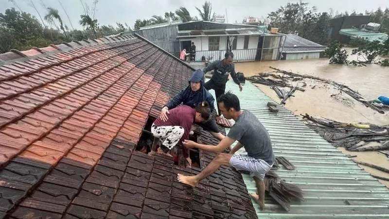 Người dân phải thoát qua mái nhà khi lũ dâng cao. Ảnh: TTXVN