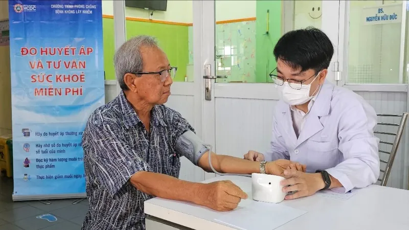 Nhân viên y tế đo huyết áp cho người cao tuổi