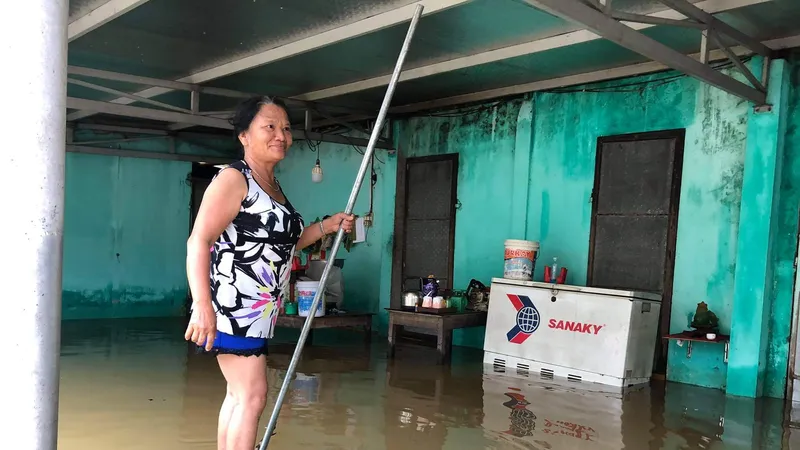 Bà Lê Thị Hồng chèo mảng chuối vật lộn trong lũ. Ảnh: ĐẶNG ĐẠI