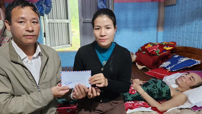 Đại diện UBND xã Lâm Hóa, Tuyên Hóa, Quảng Bình trao 18 triệu của bạn đọc Báo SGGP đến vợ bác sĩ Trường. Ảnh: DƯƠNG QUANG 