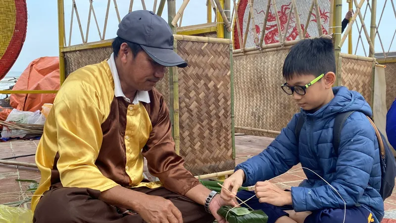 Du khách trải nghiệm gói bánh chưng