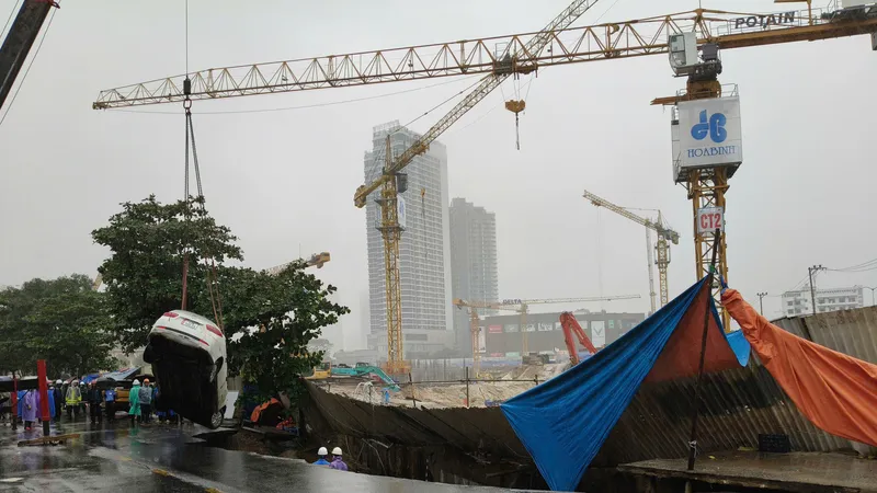 Lực lượng chức năng điều động xe cẩu cứu hộ ô tô bị rơi xuống hố